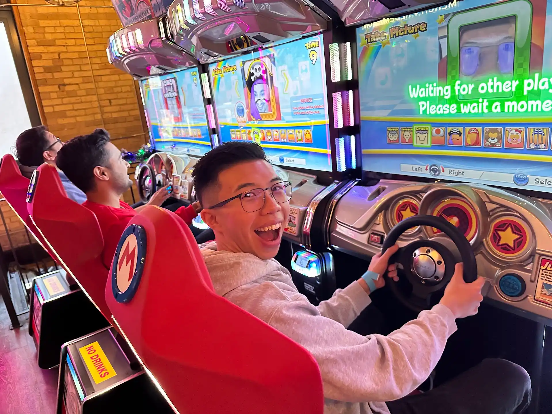 Employees enjoying the ride at an arcade bar during our Holiday Party - Dec. 2024