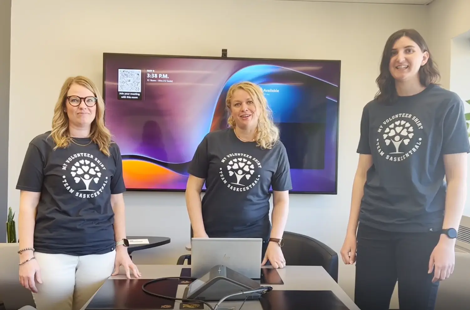 Three culture committee members rocking new volunteer shirts—smiles on, ready to make a difference!