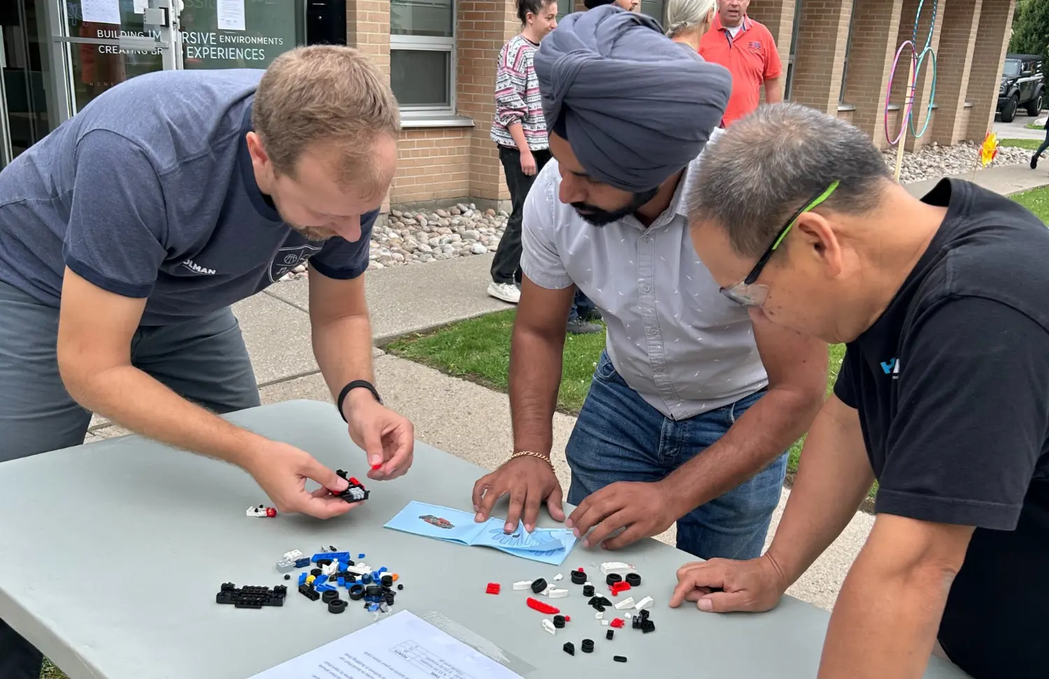 Hands-on teamwork in action, building problem-solving skills one piece at a time at our annual summertime outdoor BBQ.