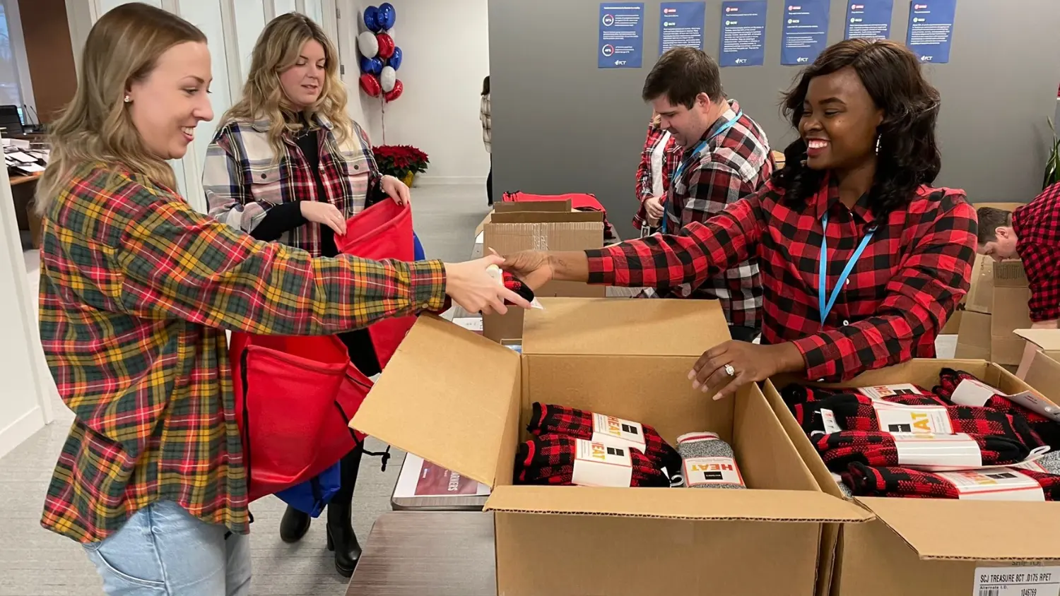 Employees participating in annual Kits for a Cause event, packing winter essentials for vulnerable youth.