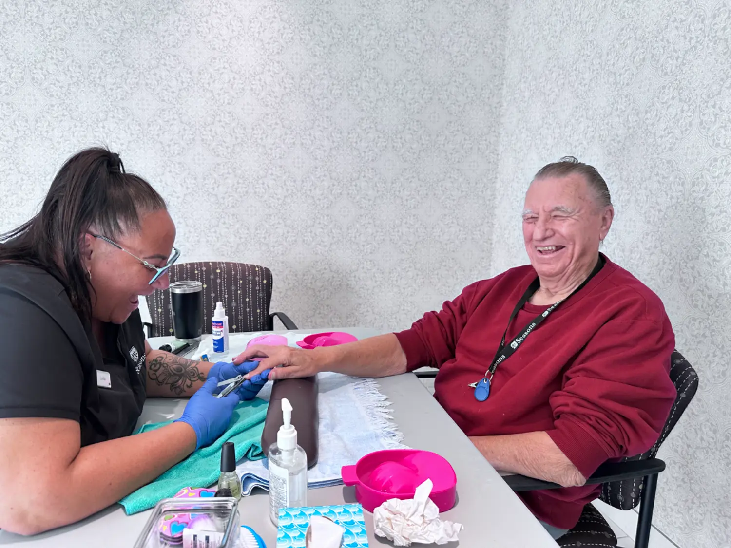 Memory Care Manager Leila gives a resident a manicure to celebrate Men's Day.