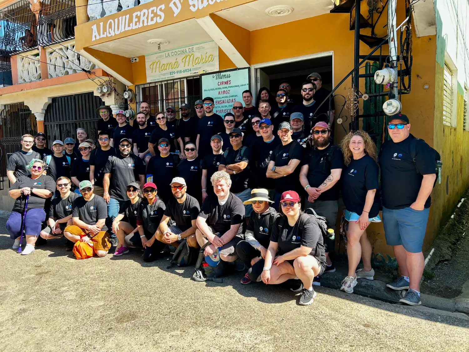 Together in person once a year: The team onsite in Nuevo Renacer, Puerto Plata outside community restaurant, Mama Marias