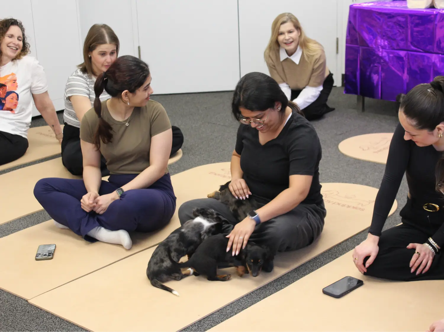 Street Haven staff participating in puppy yoga during the International Women's Day