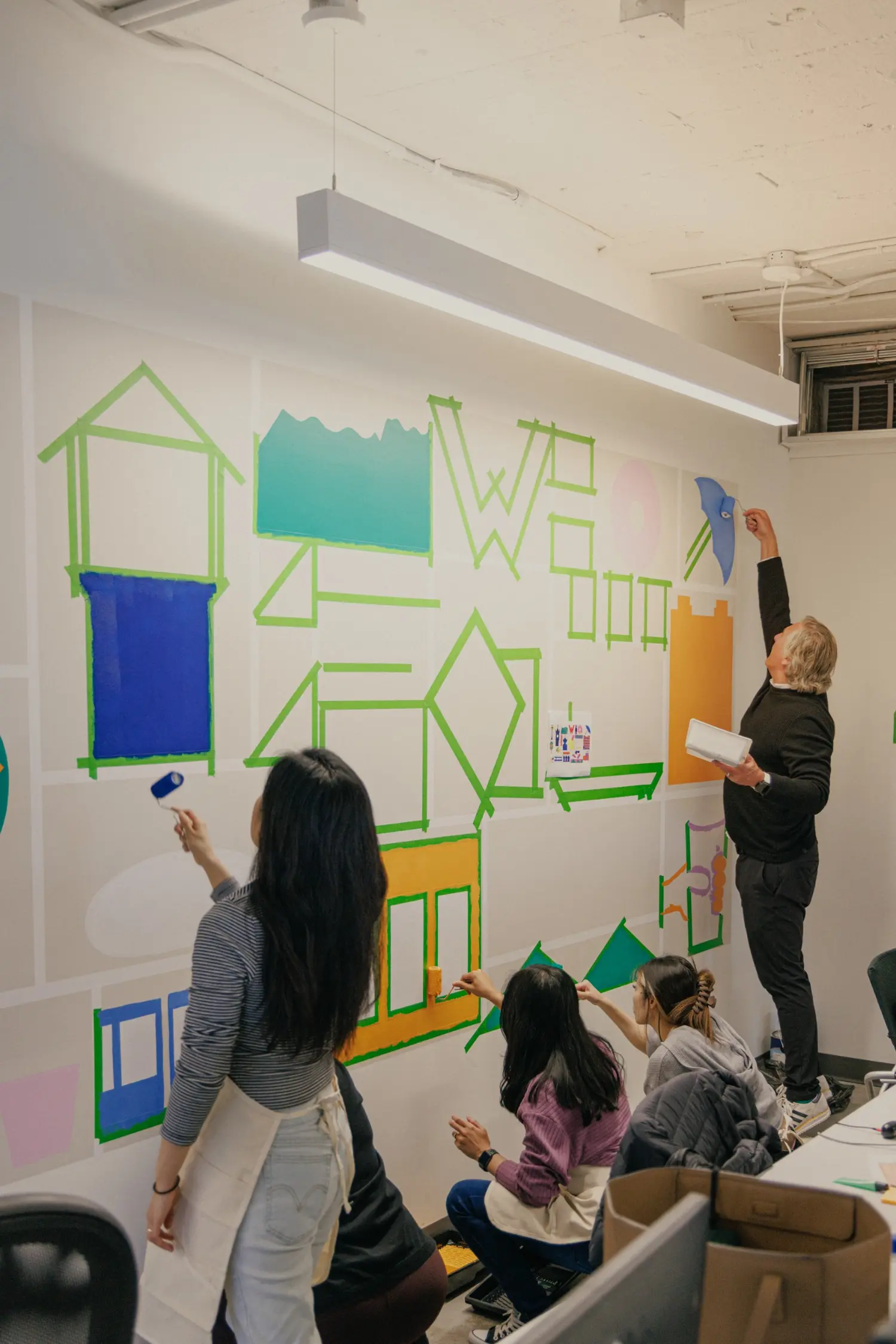 Working together to paint the new mural in our office.