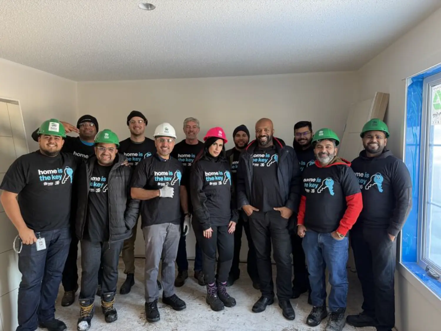 Proud Calgary team members volunteering with Habitat for Humanity, building homes and stronger communities together.